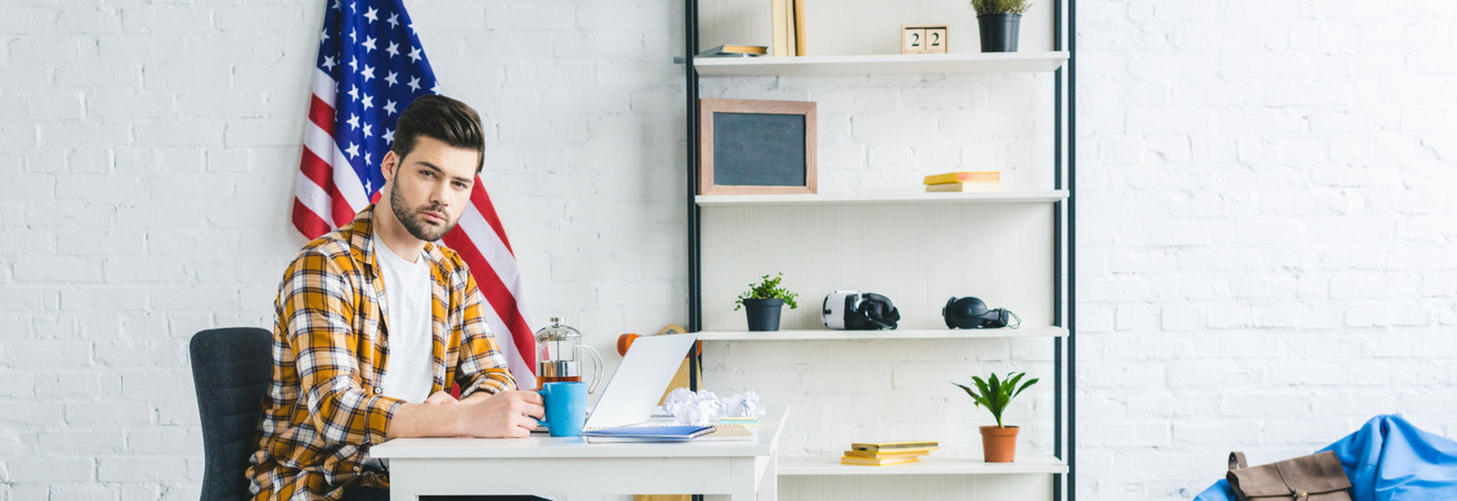 man sitting at desk with american flag in background