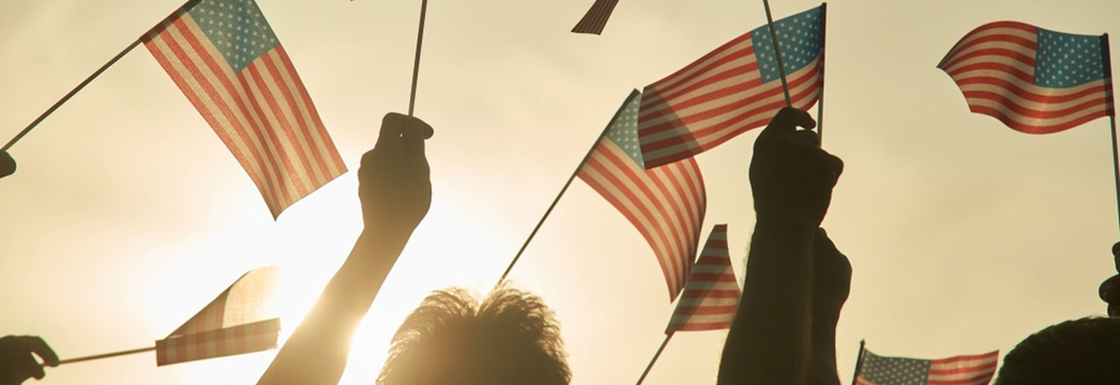 People holding small American Flags in the sky.
